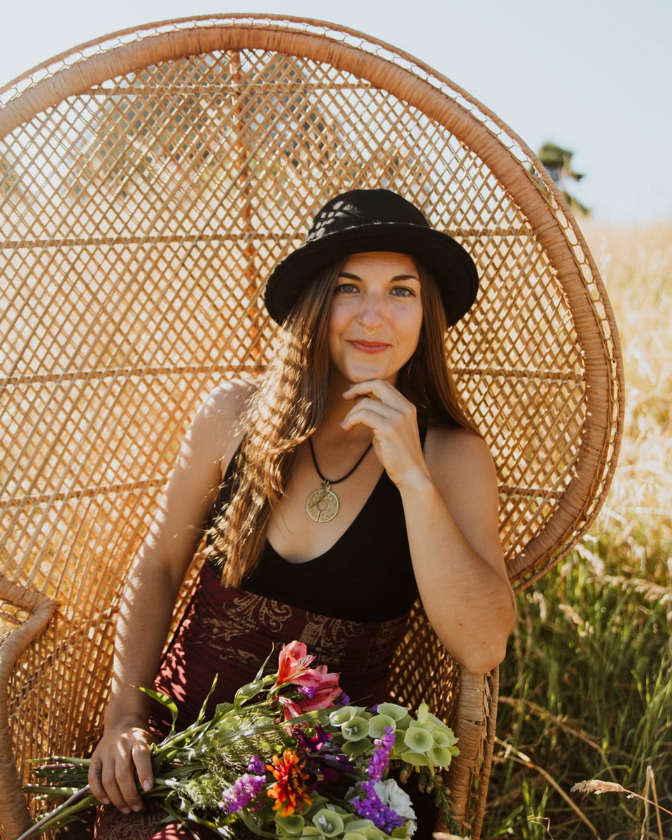 arise alchemy owner founder lauryn lavandula sitting in chair with flowers