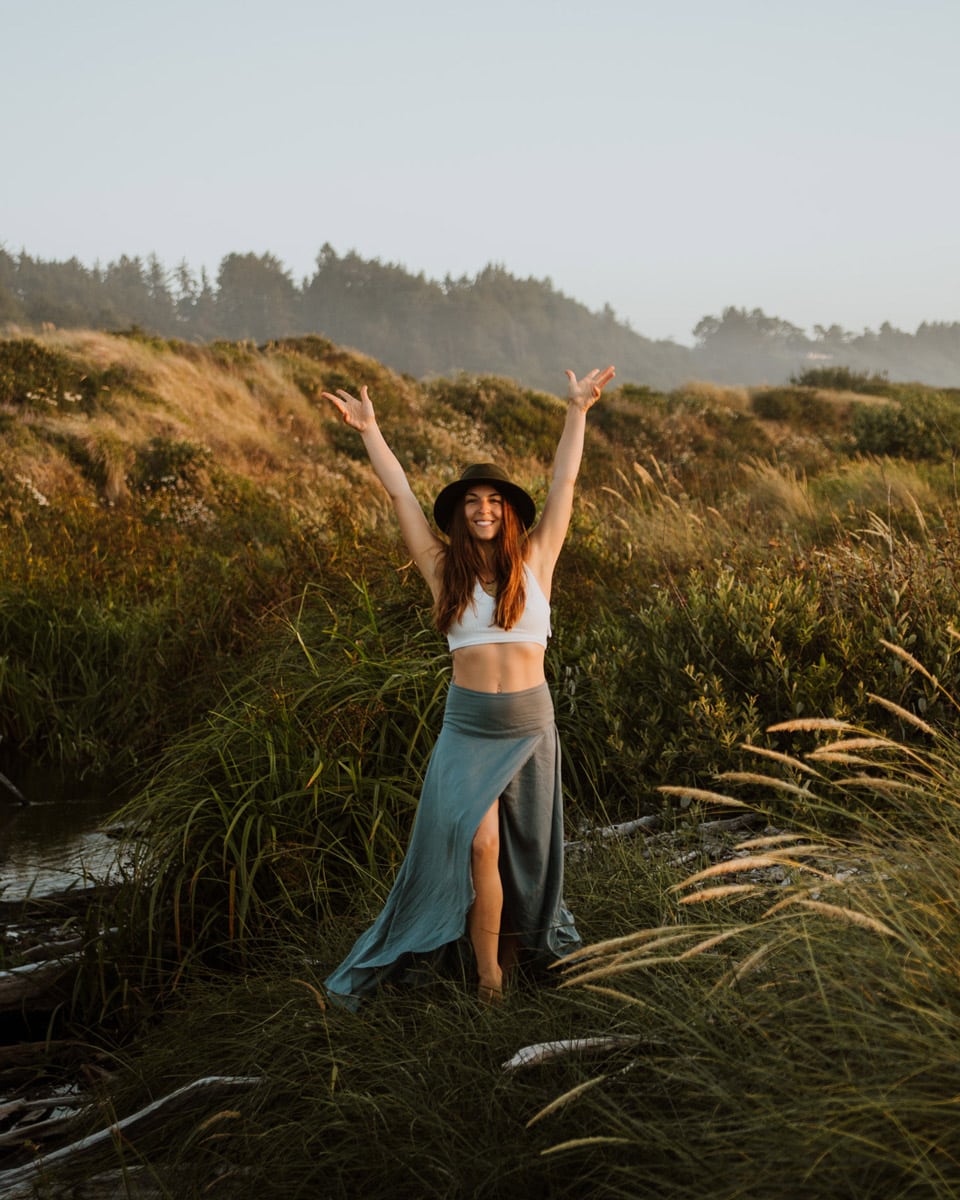 lauryn lavandula somatic coach with hands up in the bushes